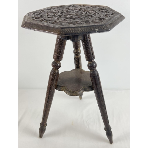 1337 - A small carved wooden 3 legged occasional table with small under shelf. Floral carving throughout to... 