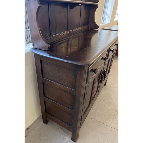 1339 - A vintage Ercol small double dresser in dark wood. Two shelves to top with shaped sides. 2 door and ... 