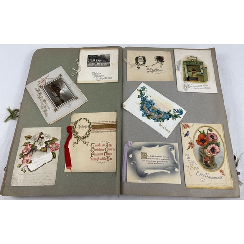 198 - An album containing 230+ assorted Victorian & Edwardian greetings cards. Each card fixed onto scrap ... 