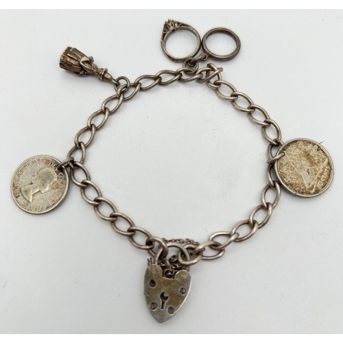 1079 - A vintage silver charm bracelet with 4 charms, padlock and safety chain. Charms include wedding and ... 