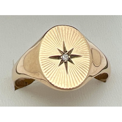 1049 - A men's vintage 9ct gold oval signet ring with central diamond and sun-ray detail to top. Full hallm... 