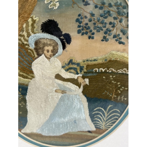 1266 - A framed and glazed fine silk embroidered panel of a Georgian lady sitting beneath a tree. In brown,... 