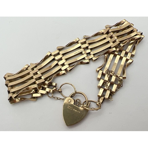 1005 - A 9ct gold 5 bar gate bracelet with heart shaped padlock clasp and safety chain. Fully hallmarked to... 