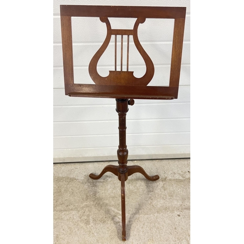 1349 - A vintage wooden music stand with tripod feet, turned pedestal shaft and lyre design to tray. Wooden... 