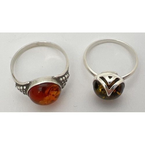 11 - 2 silver and amber dress rings with central circular cabochons. A green amber set ring of contempora... 