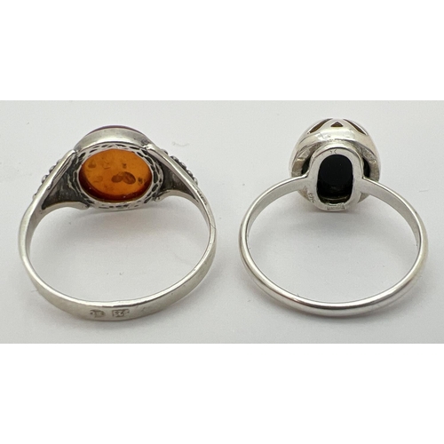 11 - 2 silver and amber dress rings with central circular cabochons. A green amber set ring of contempora... 