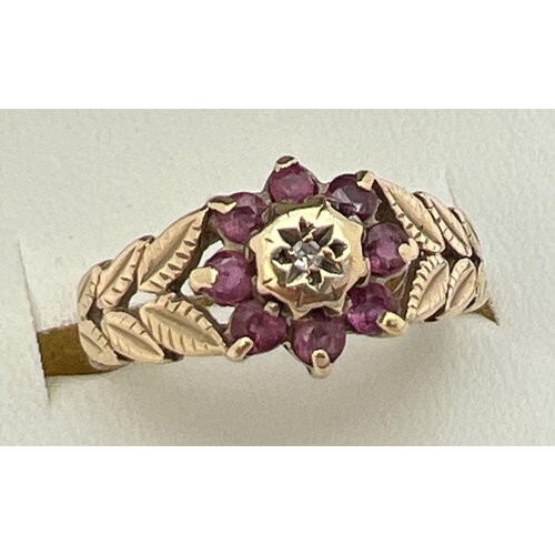 15 - A vintage 9ct gold, ruby and diamond dress ring in a flower shaped setting. Central diamond surround... 