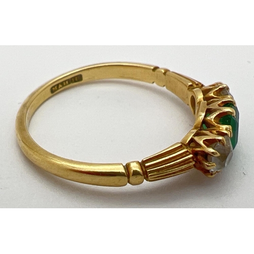 18 - A vintage 18ct gold, emerald and diamond trilogy ring with channelled design to shoulders. Central e... 