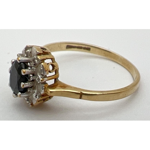 24 - A 9ct gold sapphire and diamond dress ring. Central oval cut sapphire with 4 small diamonds in an il... 