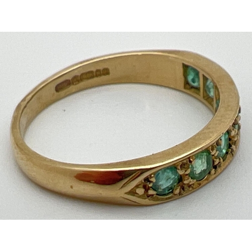 31 - A vintage 9ct gold eternity ring set with 7 round cut emeralds. Fully hallmarked inside band. Ring s... 