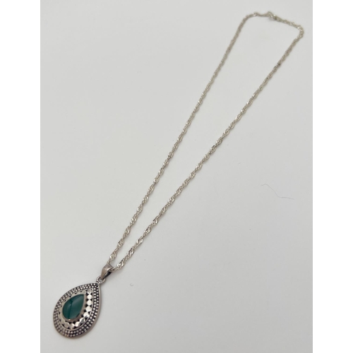 33 - A 925 silver tear drop shaped pendant set with central green stone and with decorative mount. On an ... 