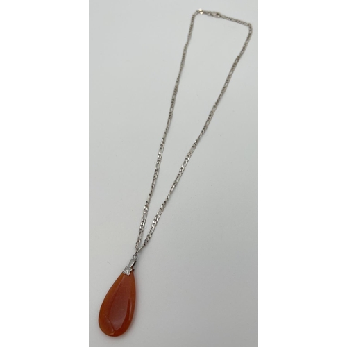 50 - A teardrop shaped orange jade pendant on a silver 18