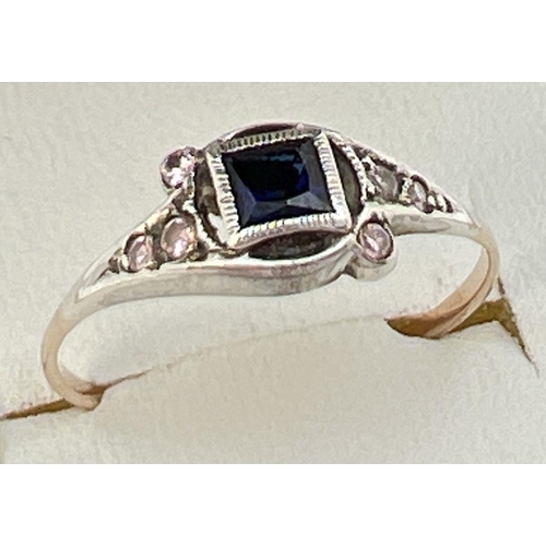 51 - A small Art Deco dress ring with central square cut sapphire flanked by small pink stones in a decor... 