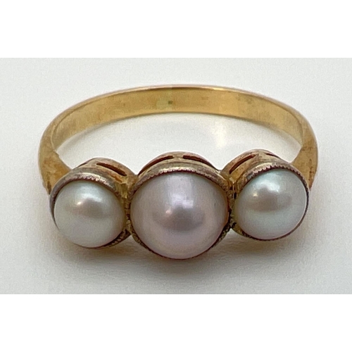 52 - A vintage unmarked 18ct gold 3 stone pearl ring, tests as 18ct gold. Ring size N.