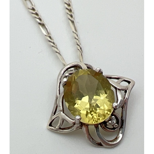 60 - A silver and citrine pendant with decorative pierced work mount (approx. 2.25cm long). On an 18