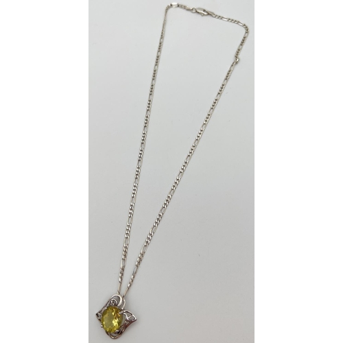 60 - A silver and citrine pendant with decorative pierced work mount (approx. 2.25cm long). On an 18