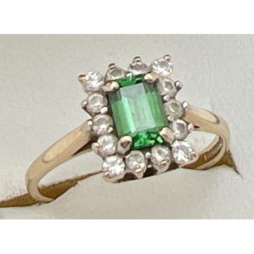 62 - A 9ct yellow gold cluster style cocktail ring with central rectangular cut emerald. Surrounded by 14... 