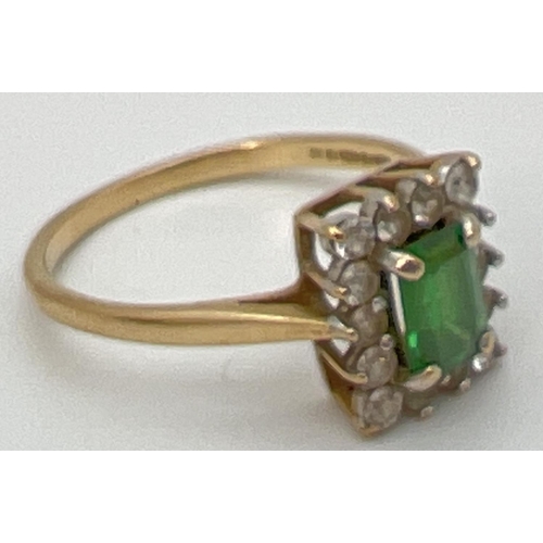 62 - A 9ct yellow gold cluster style cocktail ring with central rectangular cut emerald. Surrounded by 14... 