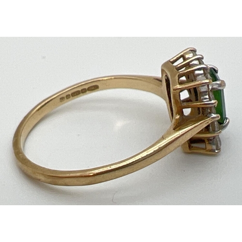 62 - A 9ct yellow gold cluster style cocktail ring with central rectangular cut emerald. Surrounded by 14... 