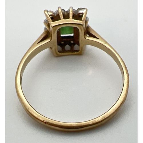 62 - A 9ct yellow gold cluster style cocktail ring with central rectangular cut emerald. Surrounded by 14... 