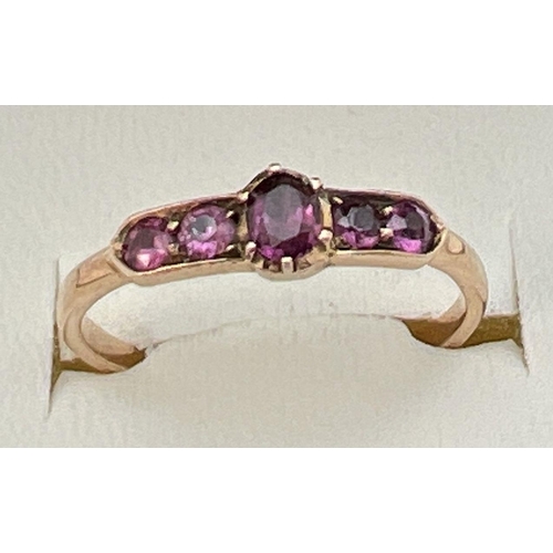 64 - A vintage Art Deco unmarked 18ct gold and amethyst ring. Central oval cut stone flanked by 2 pairs o... 