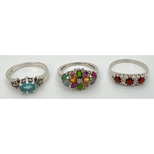 68 - 3 silver stone set dress rings. An unmarked multi stone ring in a floral style setting (size M½), a ... 