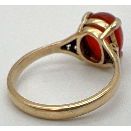 71 - A vintage 9ct gold ring set with central oval cabochon of carnelian. Claw setting with decorative sh... 