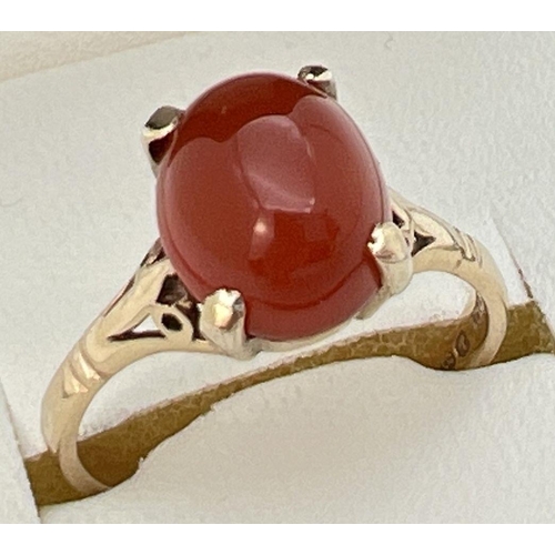 71 - A vintage 9ct gold ring set with central oval cabochon of carnelian. Claw setting with decorative sh... 