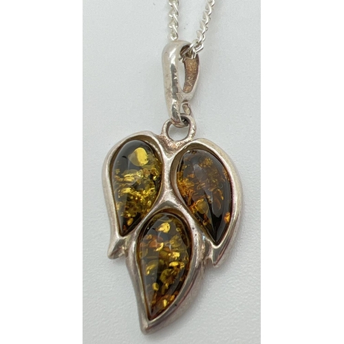 74 - A green amber set leaf shaped pendant in white metal mount, on a 20