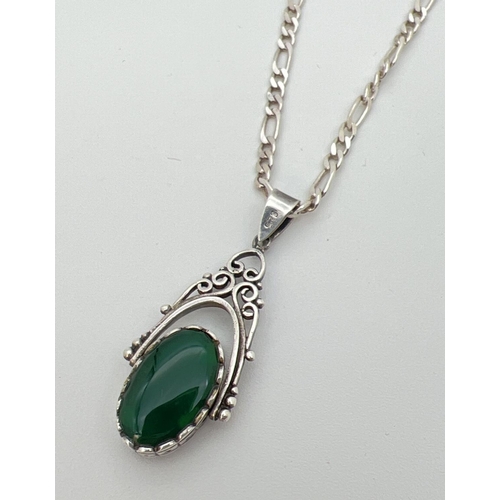 82 - A silver rotating fob pendant set with onyx and green stone on an 20