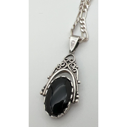 82 - A silver rotating fob pendant set with onyx and green stone on an 20