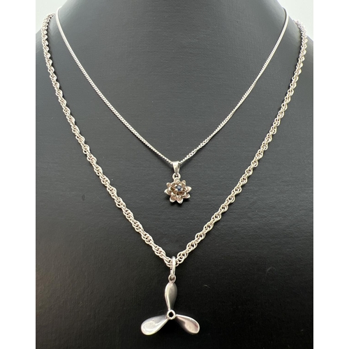 83 - 2 silver and white metal pendant necklaces. A small 925 silver flower pendant set with central sapph... 