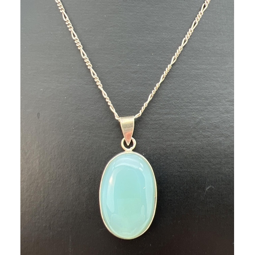 90 - An oval shaped pale blue natural stone pendant in white metal mount, on an 18