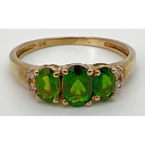 97 - A 9ct gold chrome diopside 3 stone trilogy ring, set with 2 small diamonds to each shoulder. Stamped... 