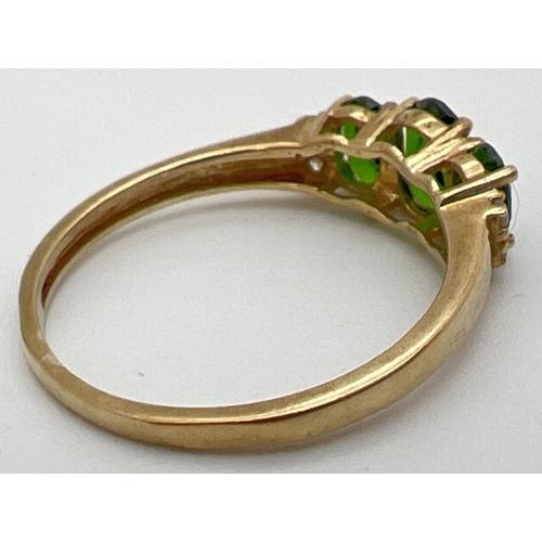 97 - A 9ct gold chrome diopside 3 stone trilogy ring, set with 2 small diamonds to each shoulder. Stamped... 