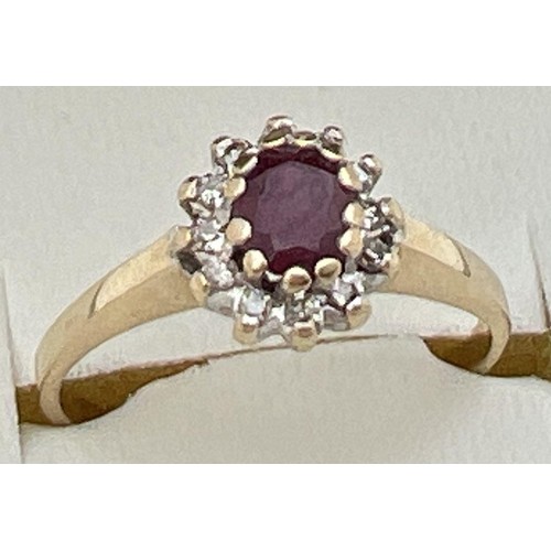 40 - An unmarked 9ct yellow gold, ruby and diamond cluster ring in a high mount. Central oval cut ruby (a... 