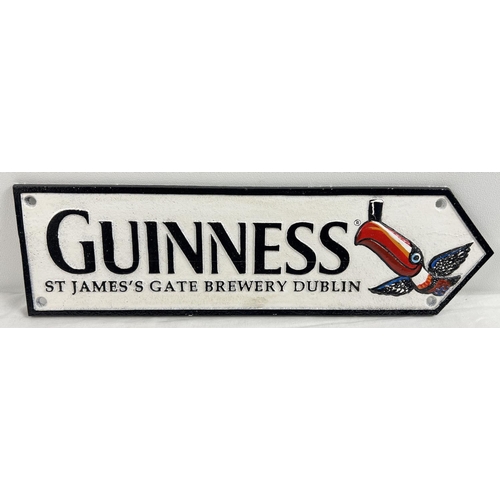 1150 - A painted cast iron Guinness wall plaque arrow with toucan detail. Approx. 38cm long.