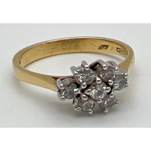 1002 - An 18ct gold and diamond ring. with 7 round cut diamonds in a flower shaped setting, totalling .35ct... 