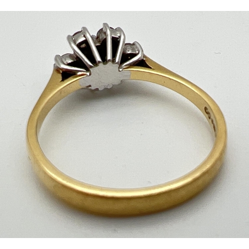 1002 - An 18ct gold and diamond ring. with 7 round cut diamonds in a flower shaped setting, totalling .35ct... 