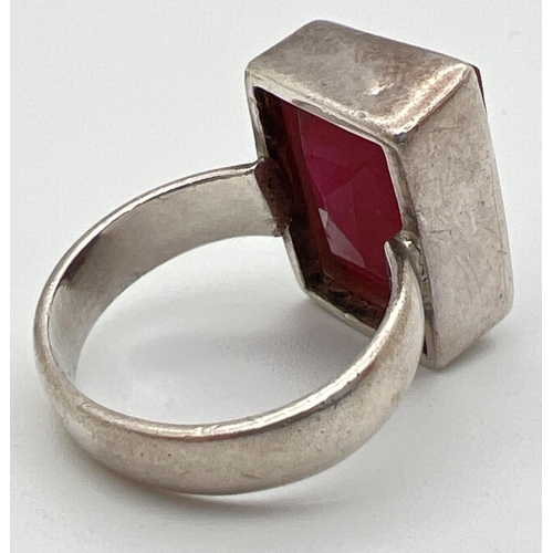 1025 - A modern silver dress ring set with a rectangular cut ruby. Inside of band marked 925. Ring size N. ... 