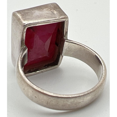 1025 - A modern silver dress ring set with a rectangular cut ruby. Inside of band marked 925. Ring size N. ... 