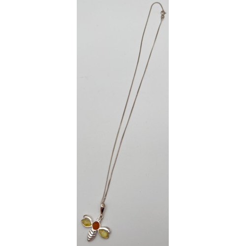 1029 - A small silver and amber pendant necklace modelled as a bumble bee and set with lemon & cognac amber... 