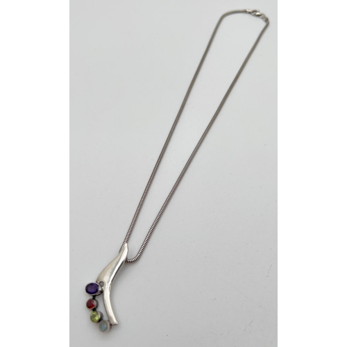 1031 - A silver and multi stone set pendant necklace on an 18