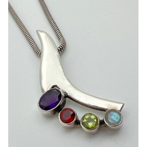 1031 - A silver and multi stone set pendant necklace on an 18