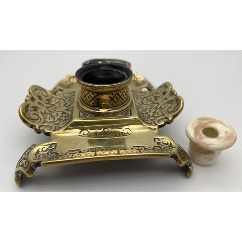 1158 - An antique brass inkwell with decorative scroll & foliate design to pen tray. Stamped '310' to under... 