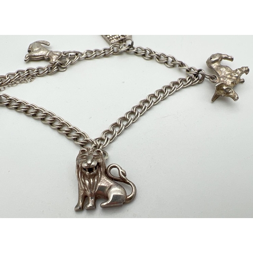 1050 - A vintage silver double curb chain charm bracelet with padlock and safety chain and 4 silver & white... 