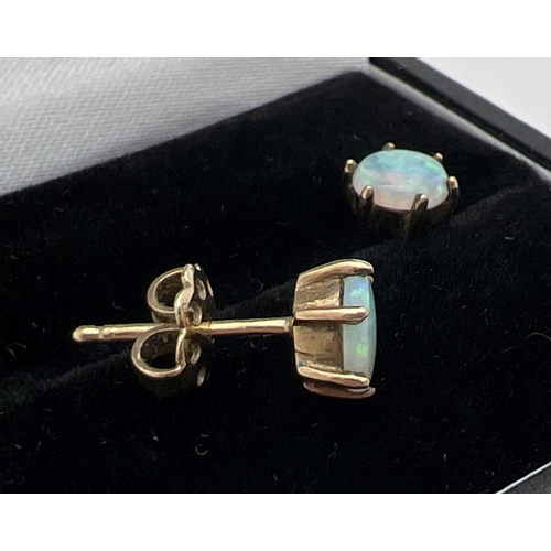 1059 - A pair of 9ct gold and opal stud earrings for pierced ears. Single round cut opal stone in a claw mo... 