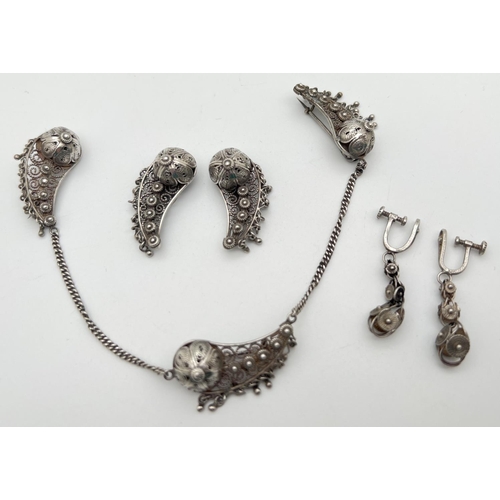 1063 - A Persian silver necklace style dress clip with matching earrings. Together with a pair of white met... 