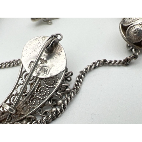 1063 - A Persian silver necklace style dress clip with matching earrings. Together with a pair of white met... 