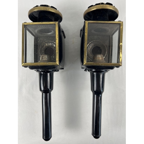 1159 - A pair of vintage carriage lamps, painted black with brass trim and red and clear glass lenses. Each... 